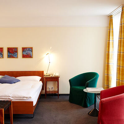 Superior-Zimmer mit modernem Teppichboden, Bett mit zwei Matratzen und einer schönen Sicht auf den See und die Berge. Helles, grosses Zimmer