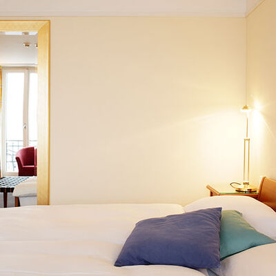 Superior-Zimmer mit modernem Teppichboden, Bett mit zwei Matratzen und einer schönen Sicht auf den See und die Berge. Helles, grosses Zimmer